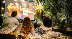 family watching movie on large screen outdoors