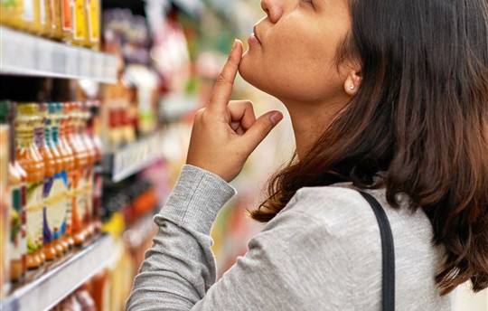 woman looking at the top shelf in the grocery aisle
