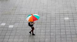 Person walking outside holding colorful umbrella