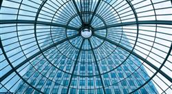 upward view of glass ceiling with a tall building in the background