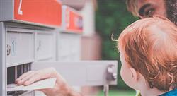a man and toddler looking into their mailbox while retrieving a piece of mail